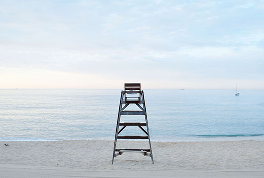 Beach with empty safeguard ladder 